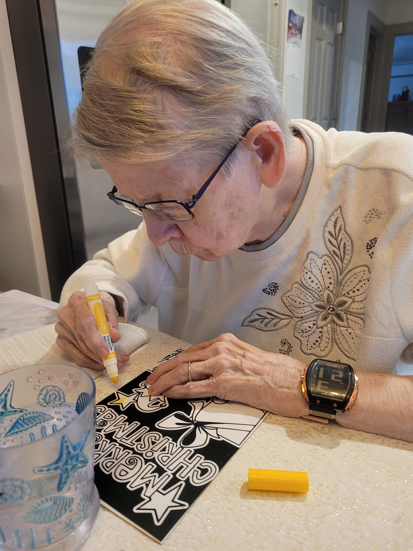 A resident carefully colouring a Christmas card design