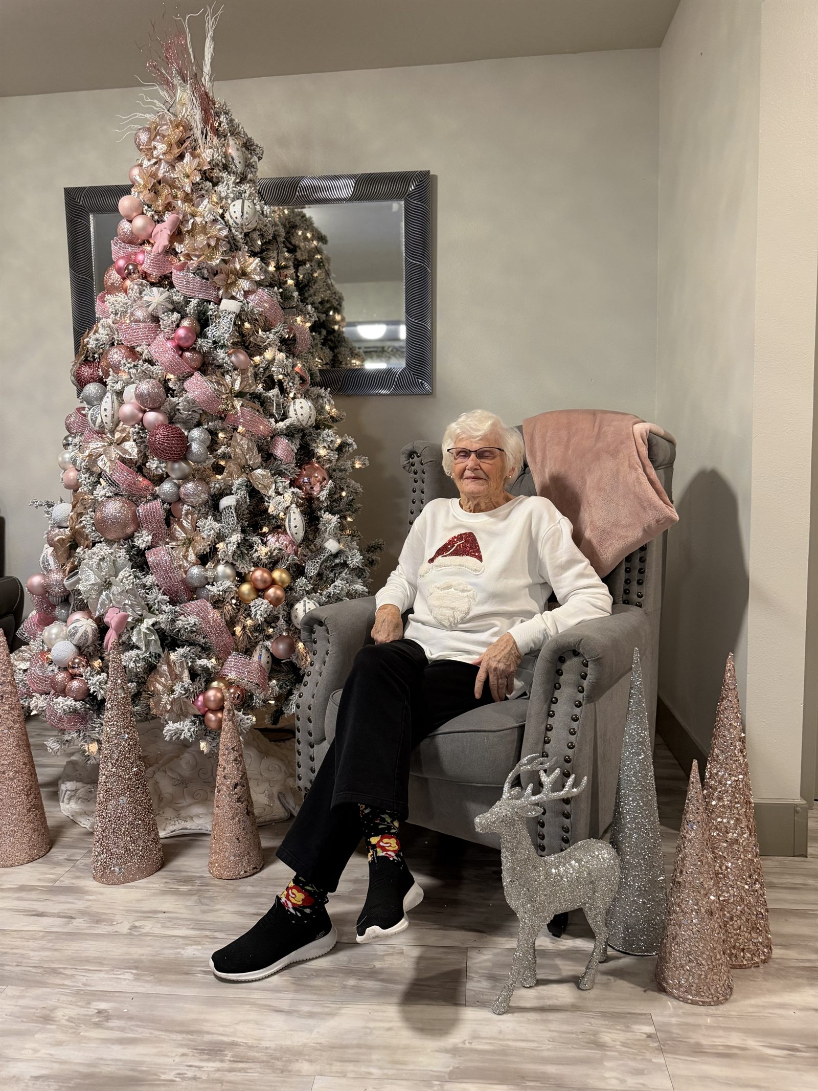 A resident in a Santa jumper beside the Christmas tree