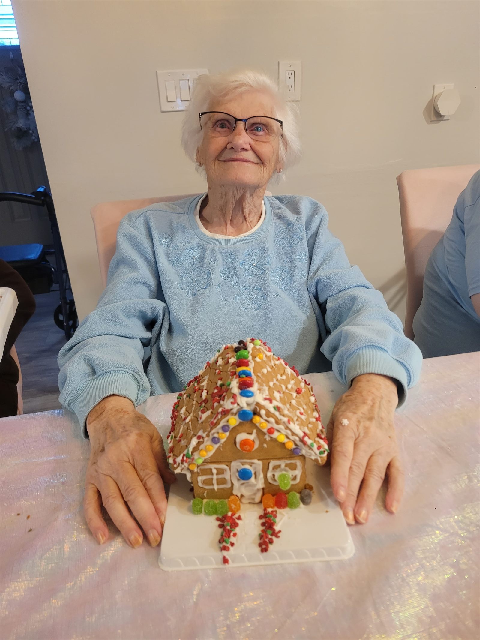 A resident with her finished gingerbread house