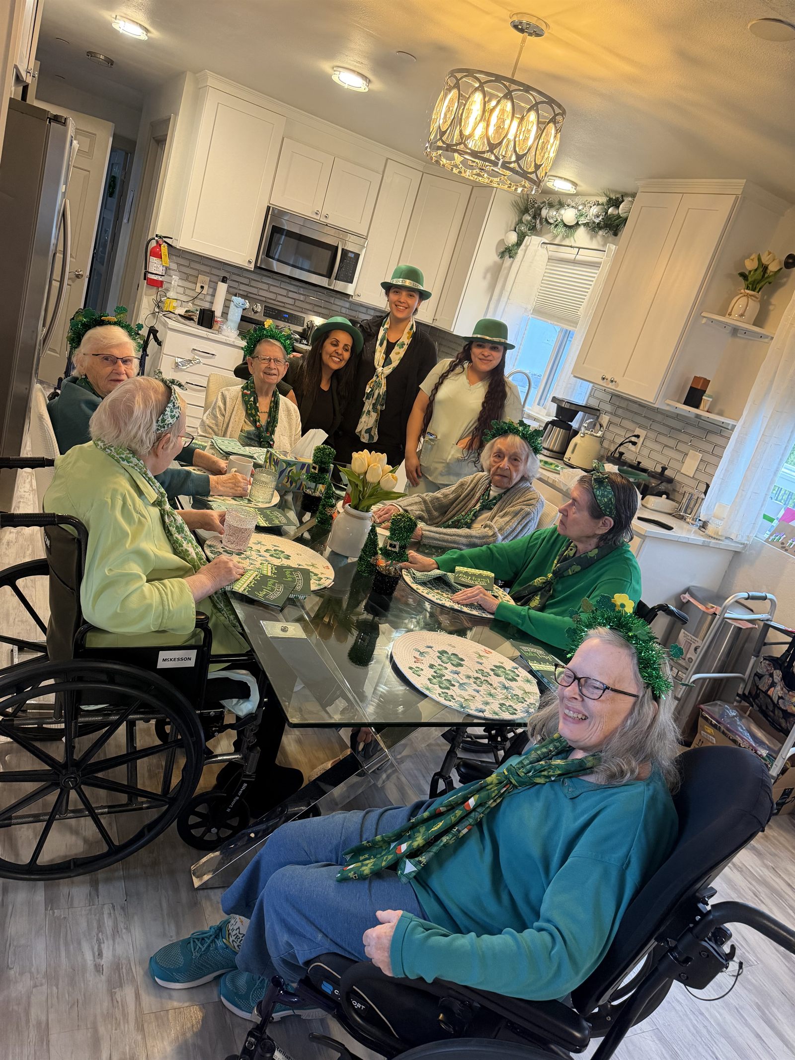 Residents and staff gathered in the kitchen wearing green