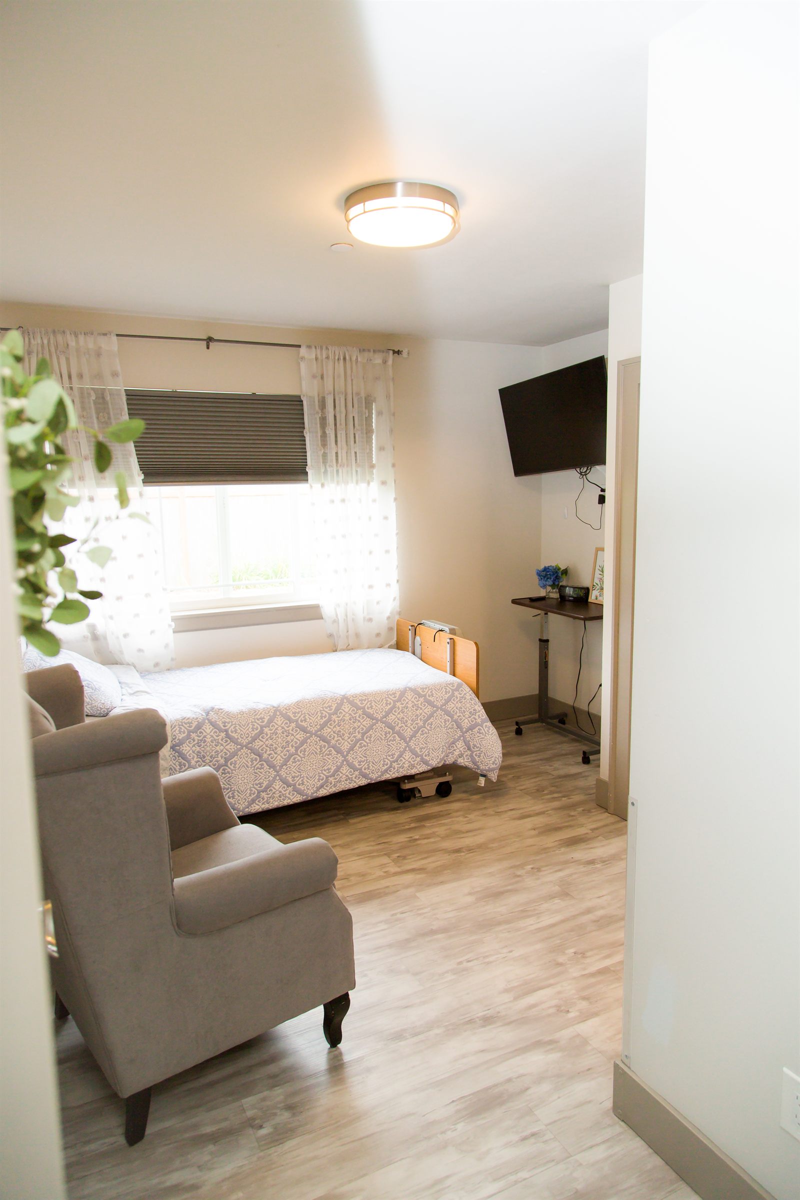 Private bedroom with a television and an adjustable bed table