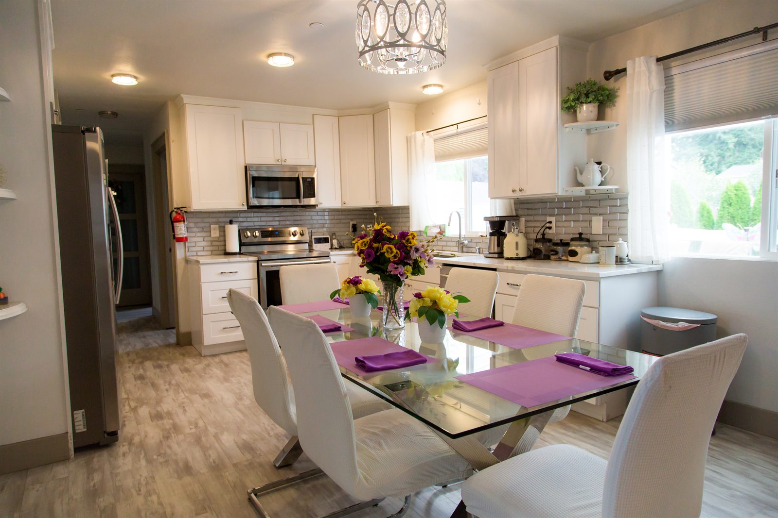 Kitchen and dining area with a glass table set for a meal