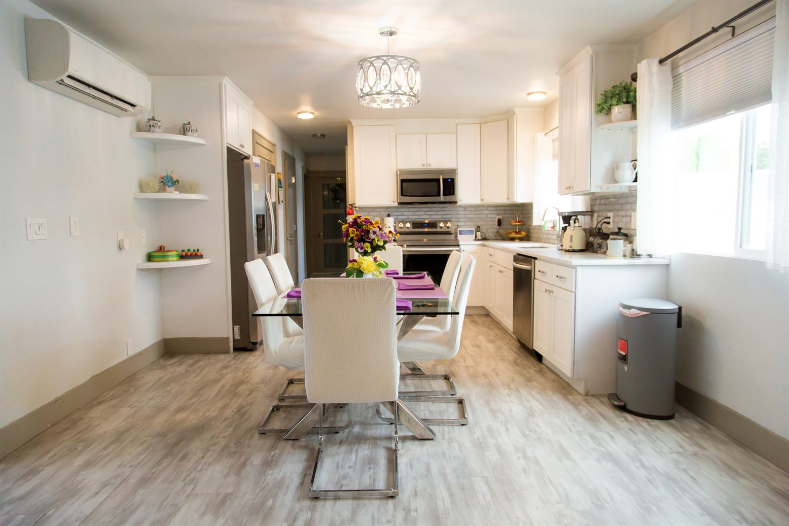 Open kitchen and dining room with a glass table set for a meal
