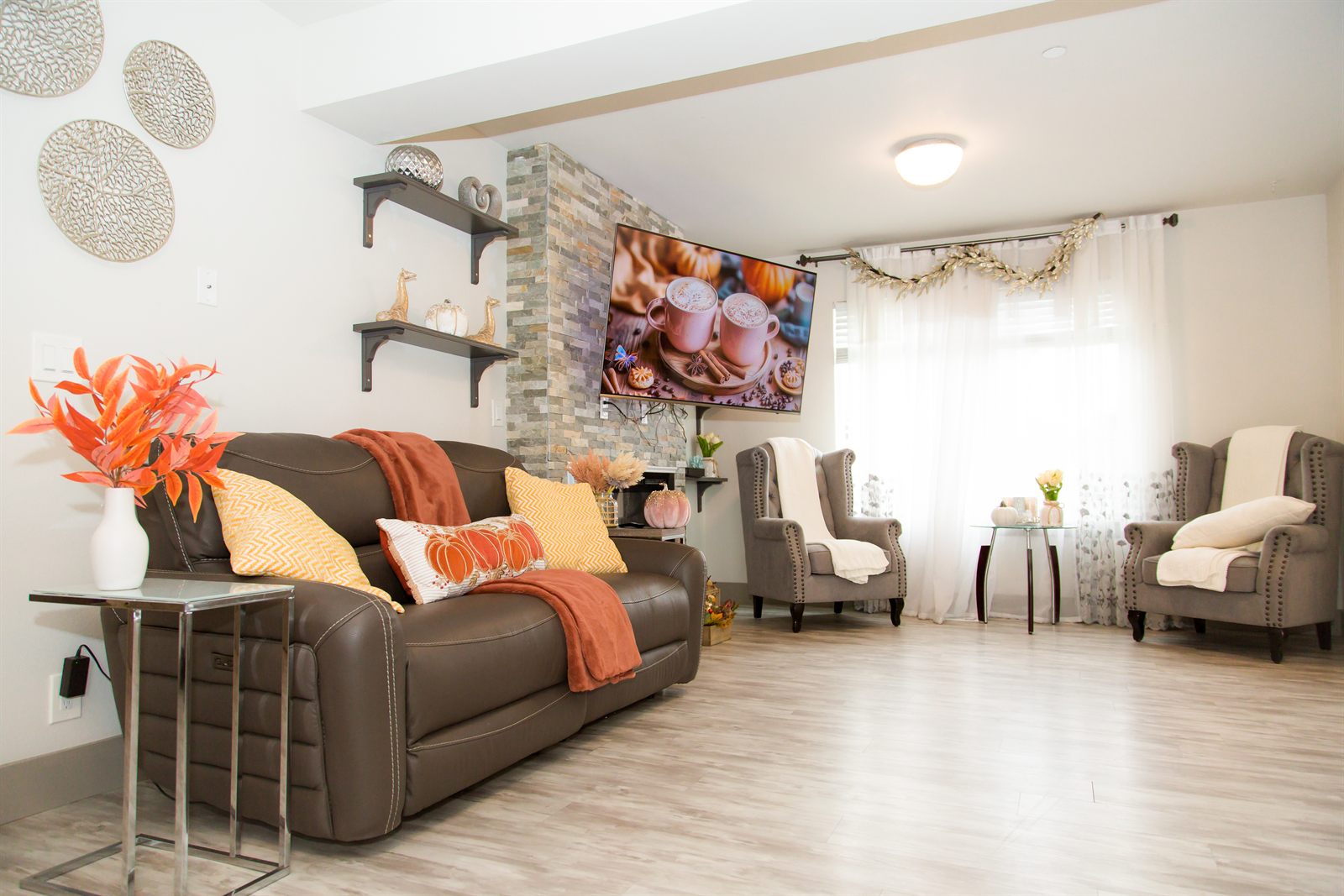 Open living room with sofa, armchairs and a stone fireplace