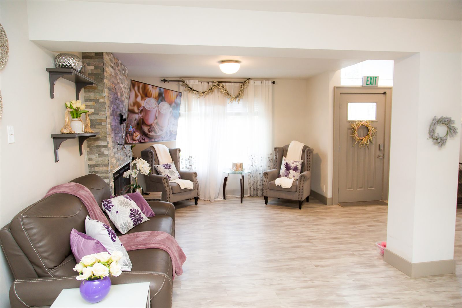 Shared living area with sofa, armchairs and the front entrance