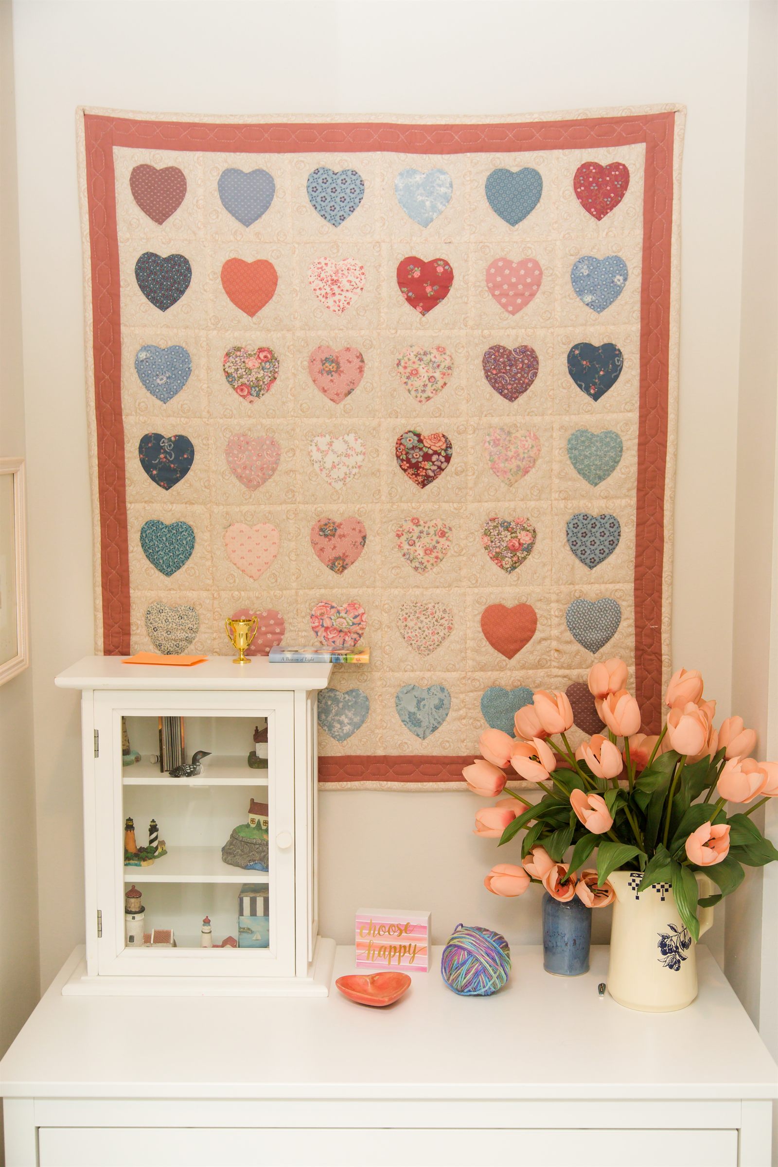 Corner display with a handmade heart quilt and fresh flowers