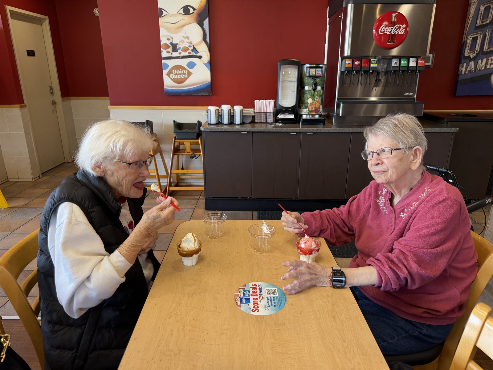 Two residents enjoying ice cream sundaes at a table