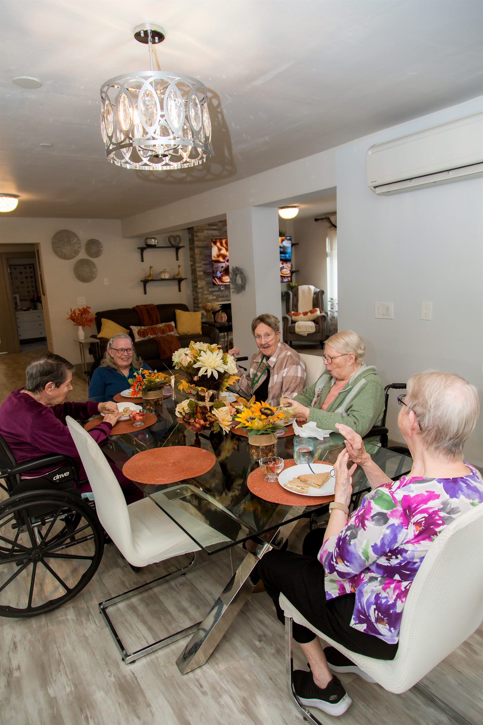 Residents talking and laughing together over lunch at the dining table