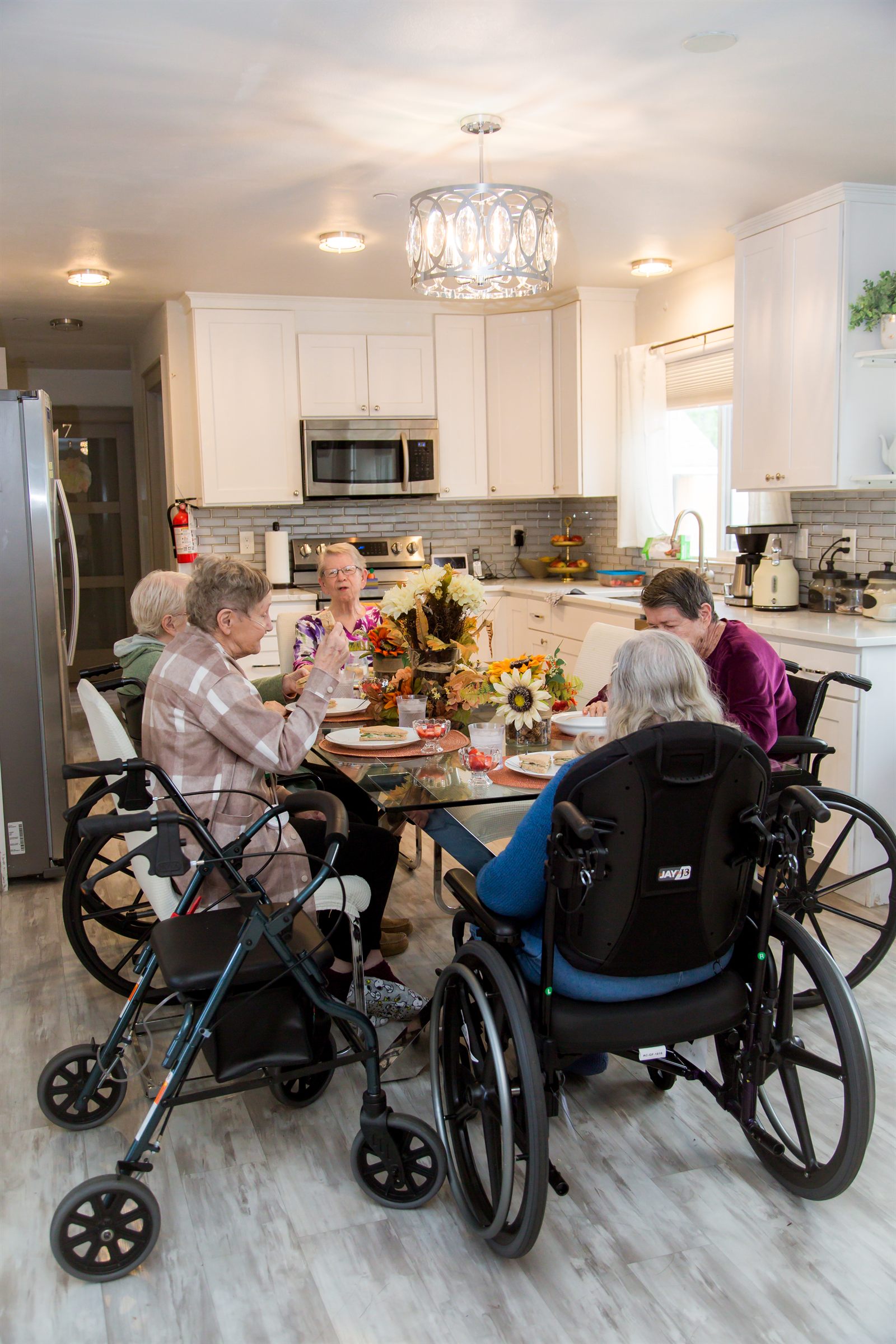 Residents gathered around the dining table with the kitchen behind them